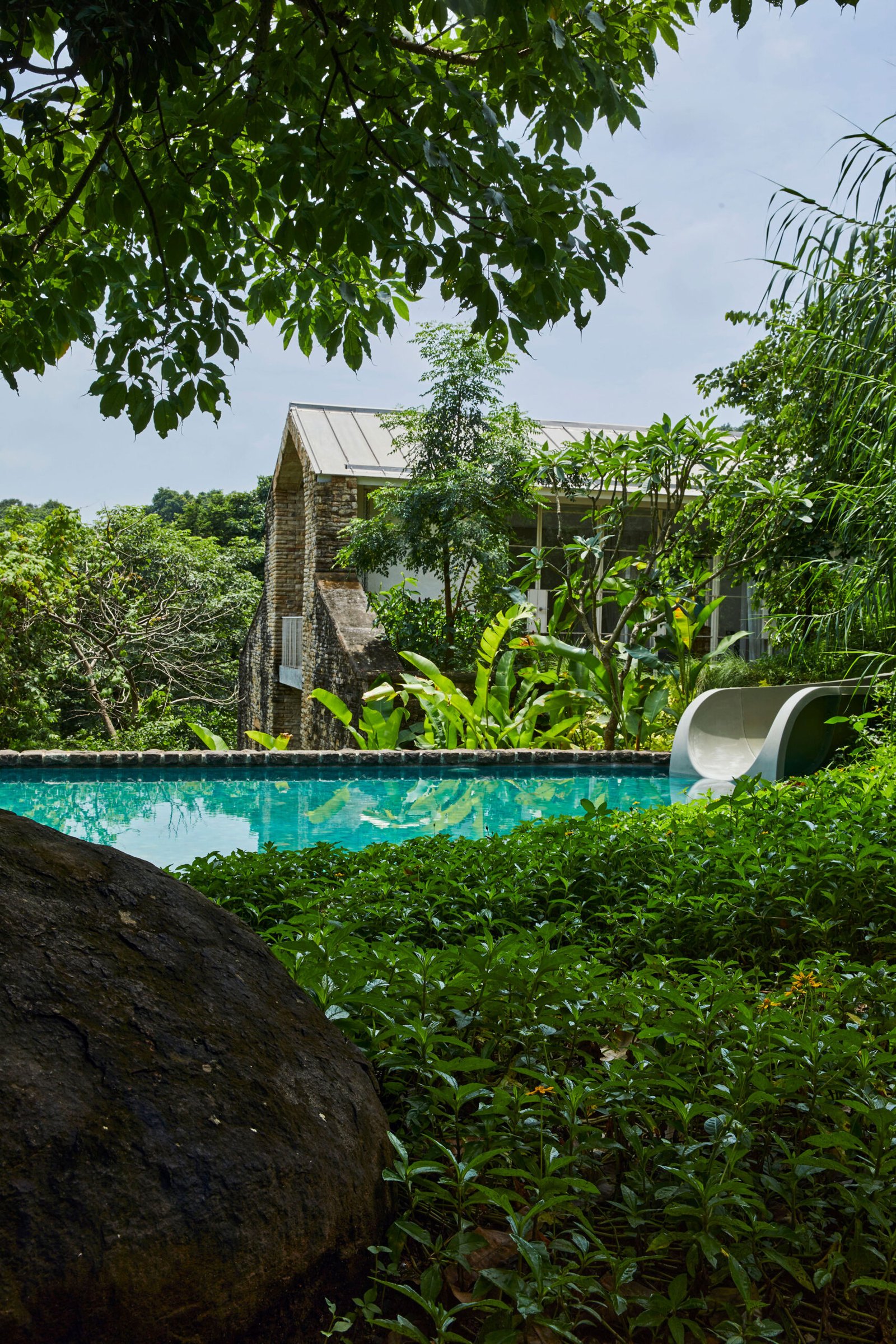 plunge pool with waterslide in tropical garden