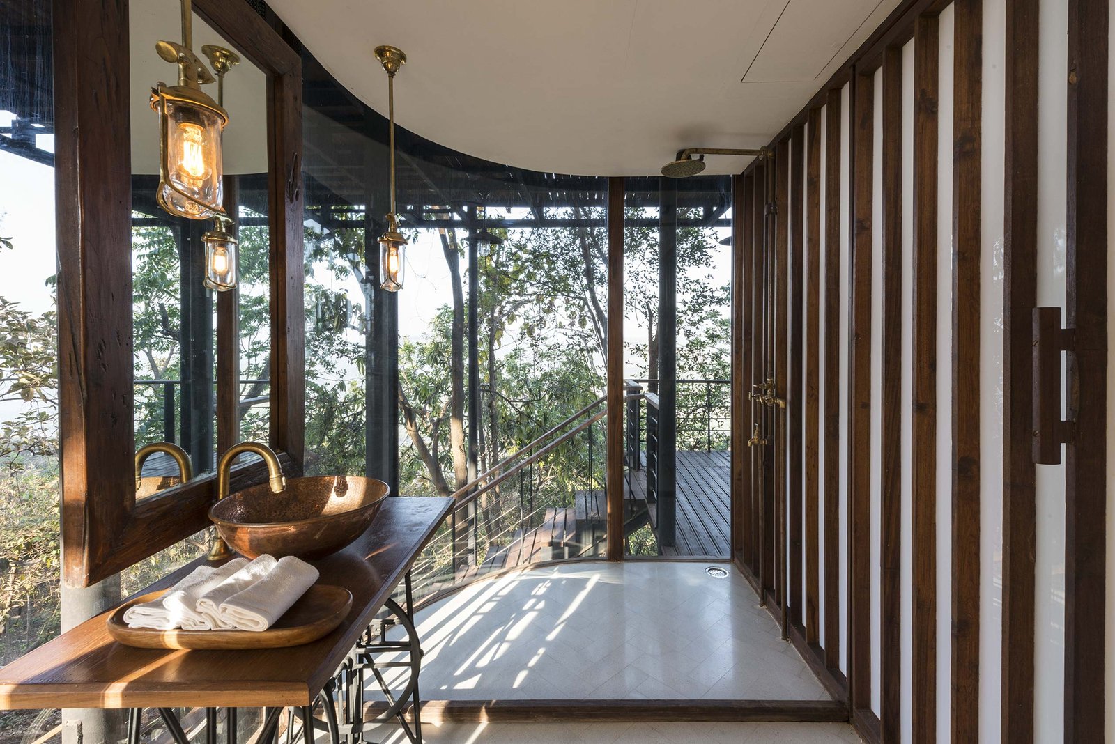 curved glass shower looking outside at tala treehouse villa alibaug india