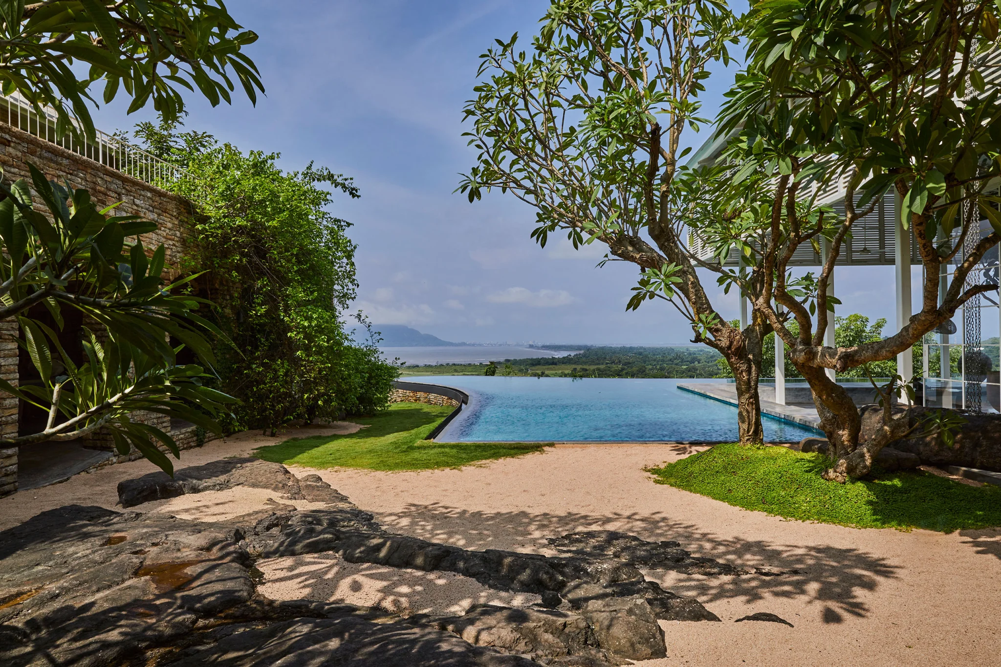 gravel beach courtyard with view of pool and bay